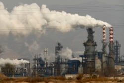 FILE - FILE - In this Nov. 28, 2019, file photo, smoke and steam rise from a coal processing plant in Hejin in central China's Shanxi Province.