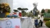 La gente reza junto a la estatua del difunto Papa Juan Pablo II afuera del Hospital Gemelli, donde el Papa Francisco está ingresado para recibir tratamiento por neumonía, en Roma, Italia, el 13 de marzo de 2025.