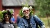 Jóvenes con guirnaldas de flores celebran el solsticio de verano durante el festival de vísperas de verano del museo al aire libre Seurasaari en Helsinki, Finlandia, país que ocupó el primer lugar en el ranking de felicidad.