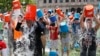 Boston City Councillor Tito Jackson, left in suit, leads some 200 people in the ice bucket challenge at Boston's Copley Square, Thursday, Aug. 7, 2014.