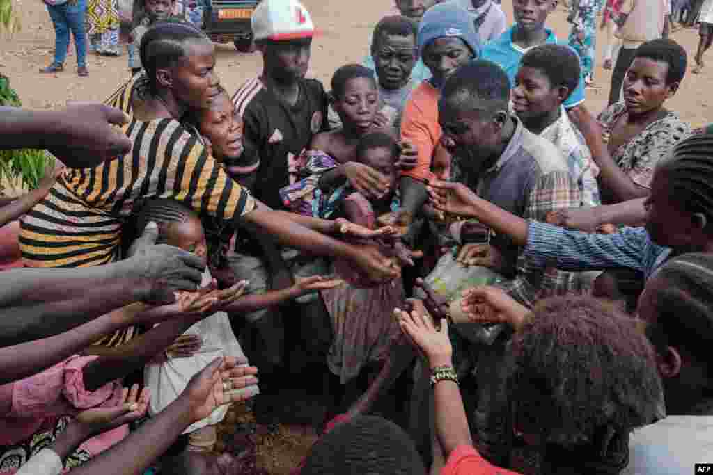 Congolese refugees, displaced by ongoing clashes in eastern Democratic Republic of Congo, gather to receive soft drinks from a social worker at the Gihanga refugee transit camp in Gihanga, Burundi on February 17, 2025.