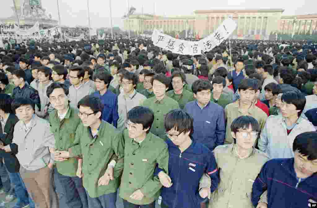 1989年4月22日，在北京天安门广场黎明时分，中国学生手挽手。他们在广场过夜，以便参加胡耀邦追悼会。