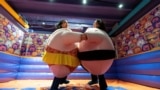 Visitors, wearing stuffed costumes, fight in the "sumo arena" at the HaHaHouse museum of laughter in central Zagreb, on January 21, 2025. (Photo by Damir SENCAR / AFP)