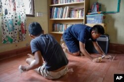 Christian Burmese refugees fix the floor of their classroom in Kuala Lumpur, Malaysia, March 11, 2017.