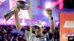 New England quarterback Tom Brady holds up the Vince Lombardi Trophy after the Patriots defeated the Seattle Seahawks 28-24 in Super Bowl XLIX, in Glendale, Ariz., Feb. 1, 2015.
