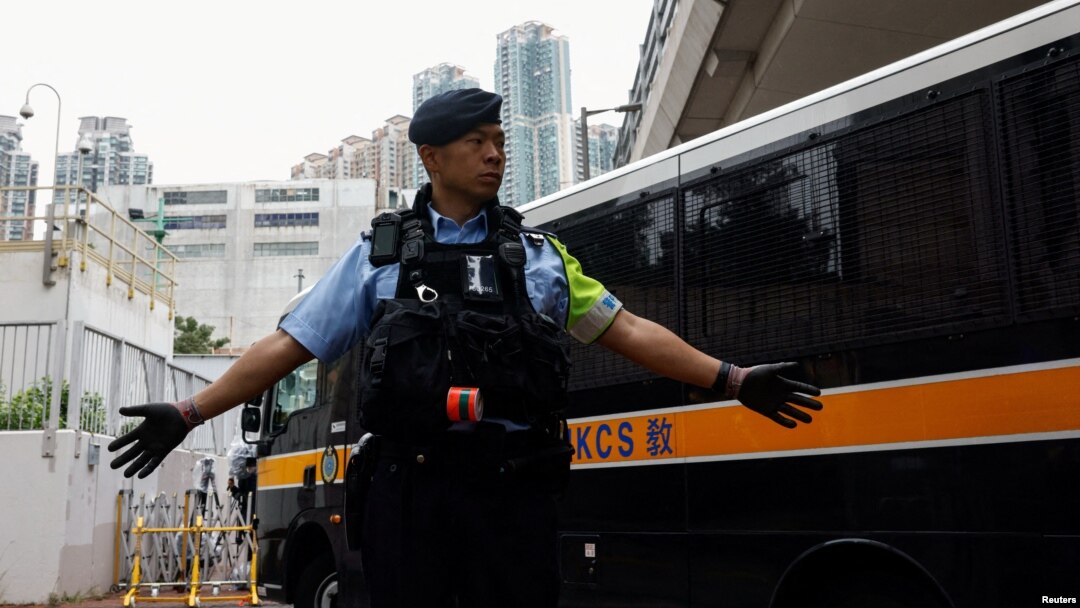 一名香港警察在一輛囚車抵達西九龍裁判法院大樓前站崗。(2024年11月19日)