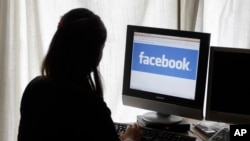 In this Monday, June 4, 2012, file photo, a girl looks at Facebook on her computer in Palo Alto, Calif. (AP Photo/Paul Sakuma, File)
