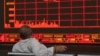Un inversionista chino observa cómo el Índice Compuesto de Shanghai cae en una correduría en Beijing, el lunes 6 de mayo de 2019. El índice de referencia Compuesto de Shanghai de China se sumerge en la amenaza Trump de más aranceles de China.