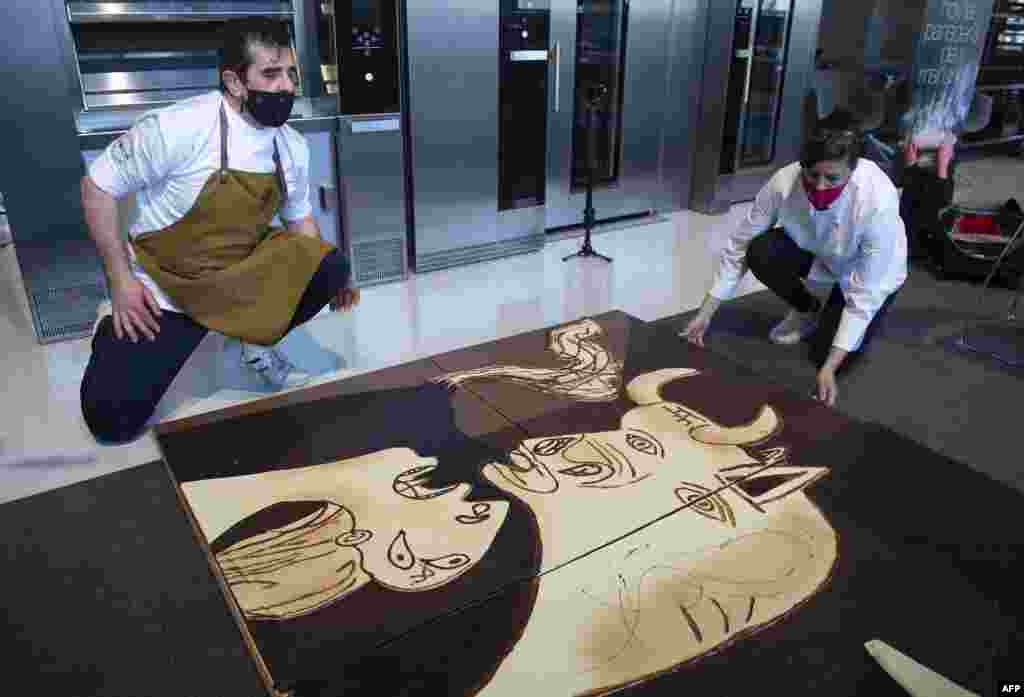 Members of Euskal Gozogileak (Basque Confectioners) association work on a life-size chocolate version of Picasso's painting "Guernica" in the Spanish Basque town of Lezo.