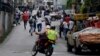 La gente huía de la policía durante los disturbios en reclamo de alimentos en Caracas, Venezuela, el jueves, 2 de junio de 2016.