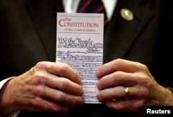 FILE - A member of Congress holds a copy of the U.S. Constitution during a press conference in the U.S. Capitol in Washington June 20, 2017.