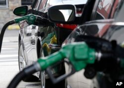 FILE - Gas is pumped into vehicles at a BP gas station in Hoboken, N.J., June 30, 2016. Federal regulators will review strict vehicle fuel efficiency standards finalized days before President Donald Trump took office.