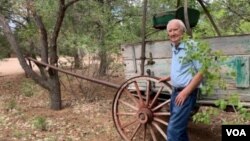 Forrest Fenn stands in front of an original 19th century cart he had placed on the old Santa Fe trail running through his property. (VOA/Penelope Poulou)