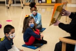Pre-kindergarten students listen as their teacher reads a story at Dawes Elementary in Chicago, Monday, Jan. 11, 2021.
