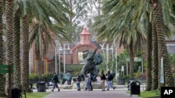 FILE - People walk past a bronze elephant on the grounds of the Audubon Zoo in New Orleans Tuesday Feb. 14, 2006. The Zoo is open only on weekends since Hurricane Katrina struck the city in August. (AP Photo/Bill Haber)