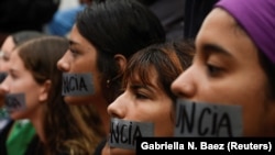 A group of women hold a silent protest with "Resign" covering their mouths with tape during the seventh day of protest calling for the resignation of Governor Ricardo Rossello in San Juan, Puerto Rico July 19, 2019.
