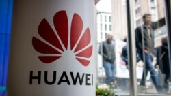 A pedestrian walks past a Huawei product stand at an EE telecommunications shop in London, April 29, 2019