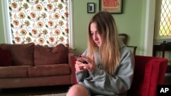 In this Nov. 1, 2018 photo, Laurel Foster holds her phone in San Francisco. Foster is among teens involved in Stanford University research testing whether smartphones can be used to help detect depression and potential self-harm. (AP Photo/Haven Daley)