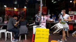 Adulwitch Tangsupmanee, 42, wearing a face mask to prevent the spread of the coronavirus disease (COVID-19), holds up a plastic chair for a customer at his late father's food stall in Bangkok's Chinatown, Thailand, October 6, 2021. (REUTERS/Athit Perawongmetha)
