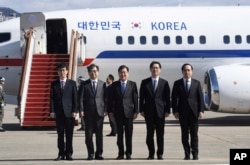 South Korea's national security director Chung Eui-yong, center, National Intelligence Service Chief Suh Hoon, second left, and other delegators pose before boarding an aircraft as they leave for Pyongyang.