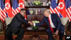 North Korea leader Kim Jong Un and U.S. President Donald Trump during their first meeting at the Capella resort on Sentosa Island Tuesday, June 12, 2018 in Singapore. (AP Photo/Evan Vucci)