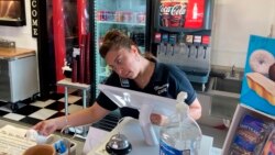 Valentina Muro rings up a customer at the Broadway Café in Van Horn, Texas, on Sunday, July 18, 2021. (AP Photo/Sean Murphy)