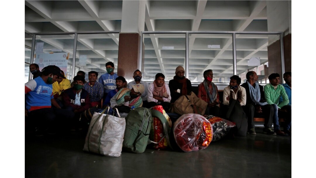 Indian migrant workers wait with their belongings inside a railway station to board trains to their home states following attacks on migrant laborers by suspected militants in Kashmir, on the outskirts of Srinagar, October 18, 2021.