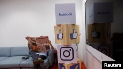 In this file photo, a man reads a newspaper at the reception area of Facebook's new office in Mumbai, India, May 27, 2016.