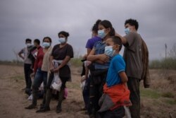 FILE - About a dozen asylum seeking unaccompanied minors from Central America are separated from other migrants by U.S. Border Patrol agents after crossing the Rio Grande river into the United States from Mexico on a raft in Penitas, Texas, U.S., March 14, 2021.