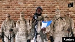 Leader of one of the Boko Haram group's factions, Abubakar Shekau speaks in front of guards in an unknown location in Nigeria in this still image taken from an undated video obtained on Jan. 15, 2018.