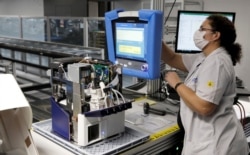 An employee of Hamilton Medical AG tests a ventilator at a plant in Domat/Ems, Switzerland March 18, 2020. REUTERS/Arnd Wiegmann