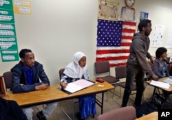 In this Feb. 25, 2016 photo, Somali refugees and current students Solub Abdi, left, and Yodit Kefle, center, study in an ESL and Adult Education class at the Career Pathways Program at Morgan Community College in Colorado.