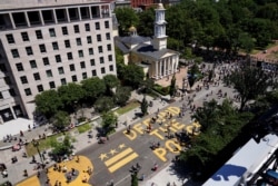 A sign painted by protesters stating "Defund the Police" is seen next to a Black Lives Matter sign as people demonstrate against the death in Minneapolis police custody of George Floyd, near the White House in Washington, U.S., June 7, 2020. (REUTERS/Josua Roberts)