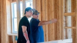 Student Shane Bhatti and teacher Ron Meinert discuss the home-building project.