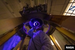 DART team members install and inspect the spacecraft’s DART's only instrument - the Didymos Reconnaissance and Asteroid Camera for Optical navigation (DRACO) - onto the spacecraft in June 2021. (Image Credit: NASA/Johns Hopkins APL/Ed Whitman)