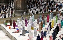 Indonesian Muslims pray spaced apart as they practice social distancing to curb the spread of the new coronavirus during an evening prayer at Istiqlal Mosque in Jakarta, Indonesia. Monday, April 12, 2021. (AP Photo/ Achmad Ibrahim)