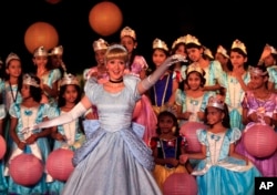 Local schoolgirls watch an actress dressed up as Disney character Cinderella perform at an event in Mumbai, India, 2012.