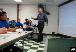 In this June 30, 2009 file photo, Larry Wostenberg teaches an engine management systems class at the WyoTech technical school, which was operated by Corinthian Colleges Inc,