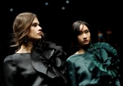 FILE - Models present creations from the Emporio Armani Autumn/Winter 2020 collection during Milan Fashion Week in Milan, Italy, February 21, 2020.
