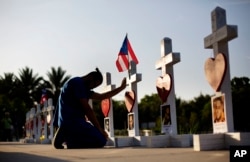 Ernesto Vergne prays at a cross honoring his friend Xavier Emmanuel Serrano Rosado and the other victims at a memorial to those killed in the Pulse nightclub mass shooting a few blocks from the club in Orlando, Florida, June 17, 2016.