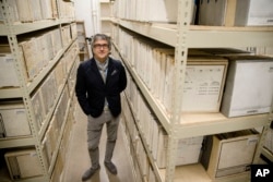 In this May 8, 2019 photo Marc Offenbach Assistant Teaching Professor, Music Industry at Drexel University poses for a portrait with music studio tapes from the Sigma Sound Studio collection, in Philadelphia.