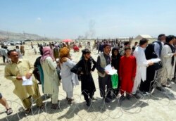 Hundreds of people gather outside the international airport in Kabul, Afghanistan, Tuesday, Aug. 17, 2021. The Taliban declared an “amnesty” across Afghanistan and urged women to join their government Tuesday.