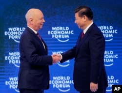 China's President Xi Jinping, right, is welcomed by World Economic Forum founder Klaus Schwab.