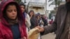 Mujeres y niños palestinos hacen cola para comprar pan en Deir al-Balah, Franja de Gaza, el jueves 28 de noviembre de 2024. (Foto AP/Abdel Kareem Hana)