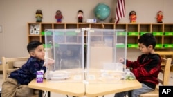 Preschool students eat lunch at Dawes Elementary in Chicago. Pressure is building on school systems around the U.S. to reopen classrooms to students who have been learning online for nearly a year.(Ashlee Rezin Garcia/Chicago Sun-Times via AP, Pool, File)