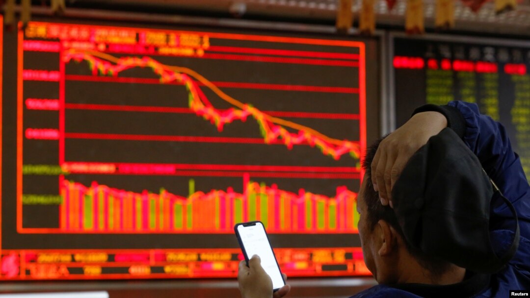 一名中國投資者坐在北京一個證券交易所的電子顯示屏前。（2018年10月11日）