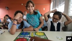 Girls play a board game at the Ramon Marin Sola Elementary School, which opened its doors as a daytime community center after the passing of Hurricane Maria in Guaynabo, Puerto Rico, Oct. 13, 2017. 