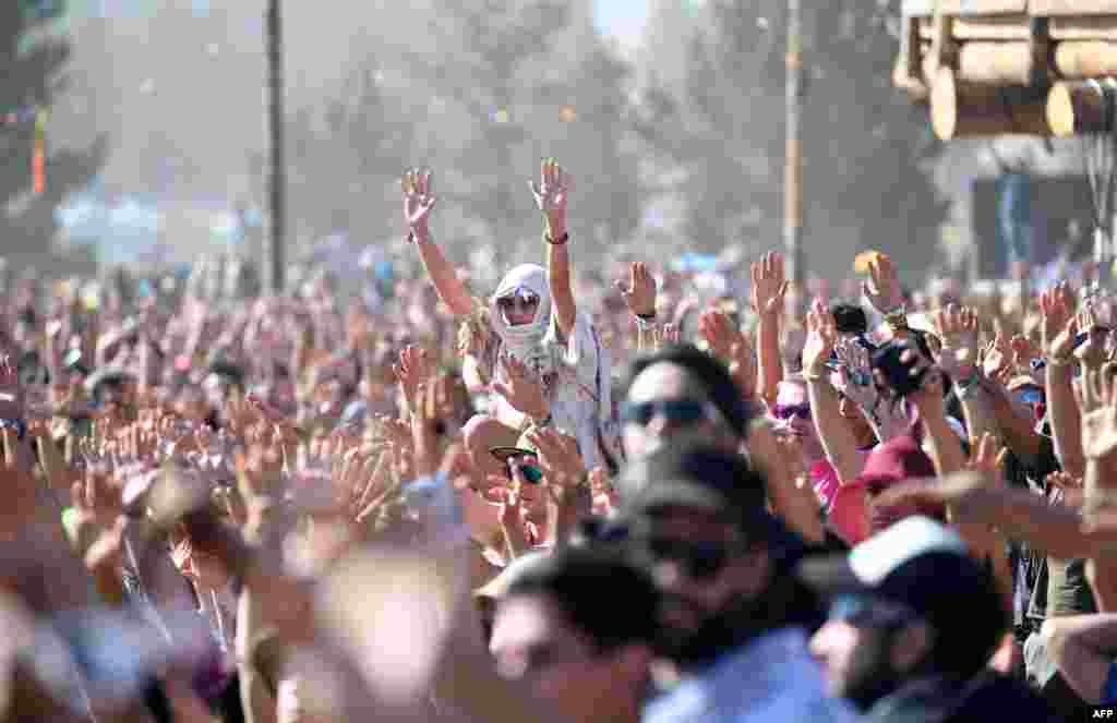 People watch the start of the solar eclipse and raise their hands in prayer in an eclipse viewing event led by Native American elders, at Big Summit Prairie ranch in Oregon's Ochoco National Forest near the city of Mitchell on August 21, 2017.