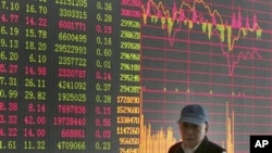 投资者走过上海证券公司的股市行情屏幕