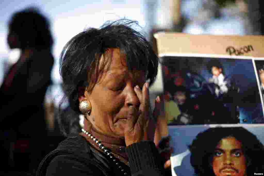Lorraine Womble wipes her eye at a vigil to celebrate the life and music of deceased musician Prince in Los Angeles, California, April 21, 2016.